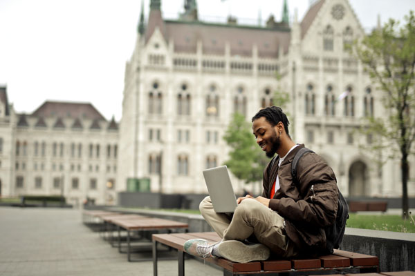 Person using laptop outside on bench