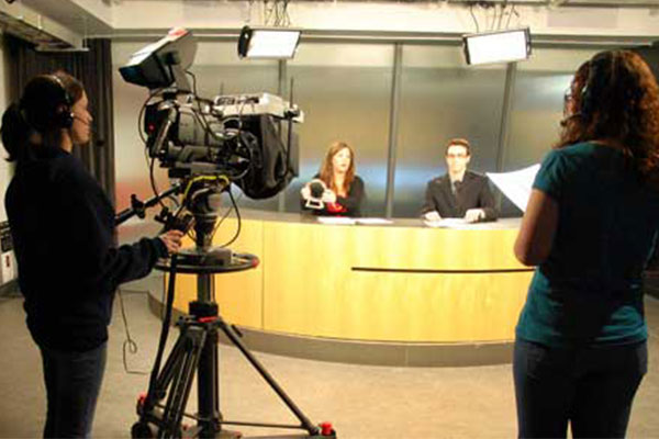 Two students filming a mock news report
