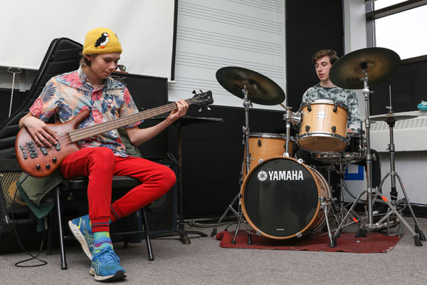 two students playing bass guitar and drums