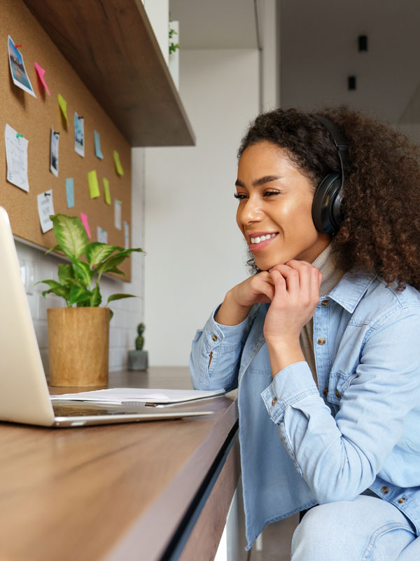 Person wearing headphones smiling at laptop