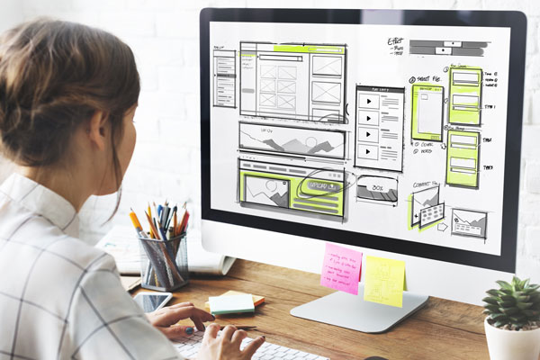 person looking at web design on monitor