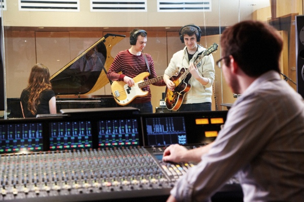 Students playing instruments in recording studio