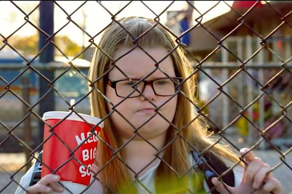 Girl looking through a fence