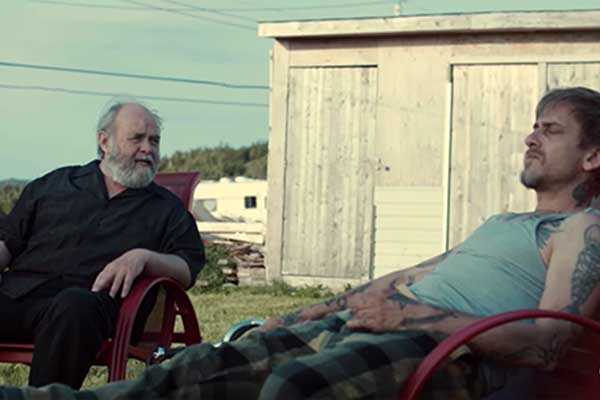 Two men talking while sitting in lawn chairs