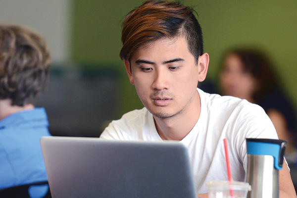 man writing on a laptop