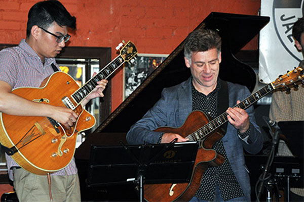 two men playing guitars