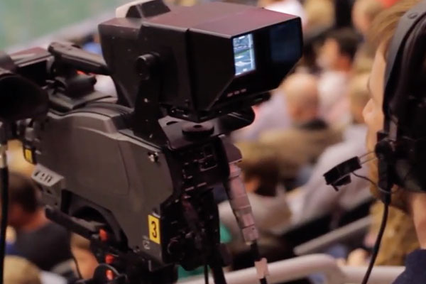 student broadcasting a sports game with a movie camera