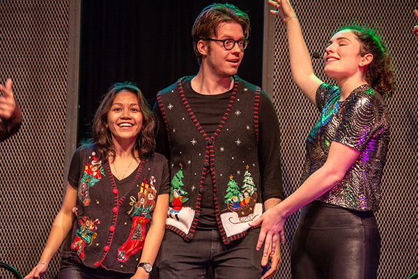 Three people on stage performing