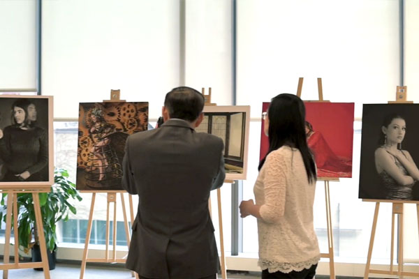 Two people looking at photographs on easels