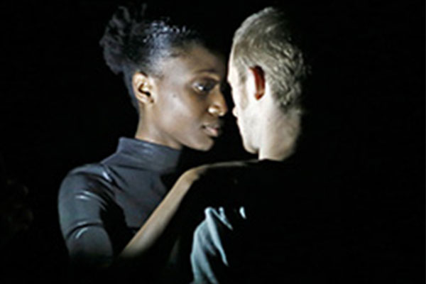 man and woman standing in a spotlight