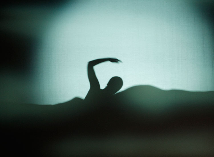 The swimmer and her coach are seen in silhouette