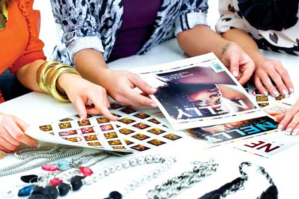 close up of hands looking through magazine spreads