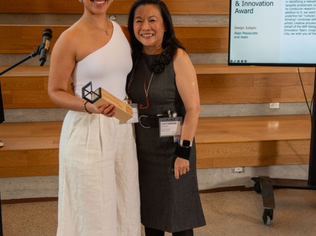 Student holding award poses with Industrial Design faculty member for photo