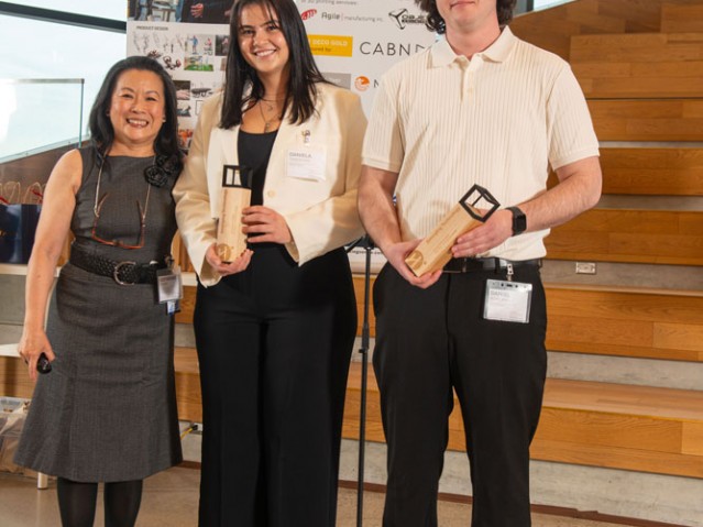 Two awarded students pose for photo with faculty member