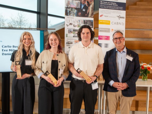 Three awarded students pose with person