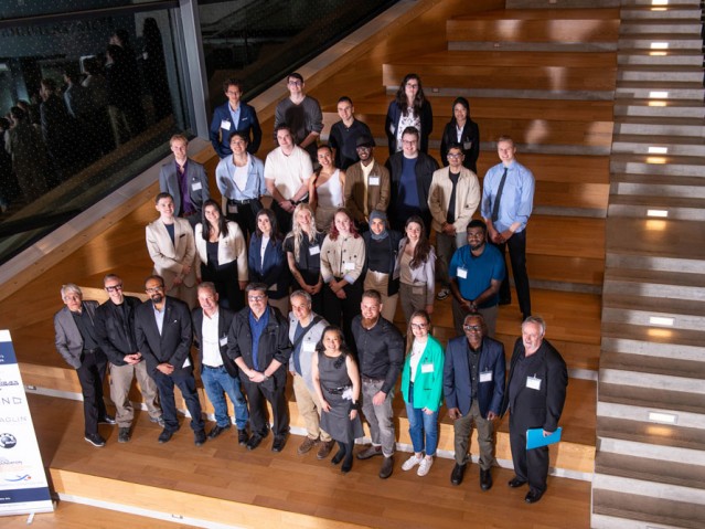 Group shot of Industrial Design students, faculty members, and event guests standing on stairs