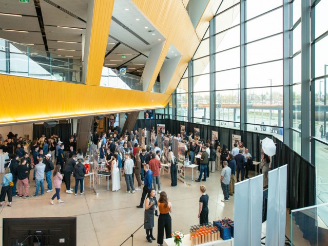 Crowd gathered inside event space mingling