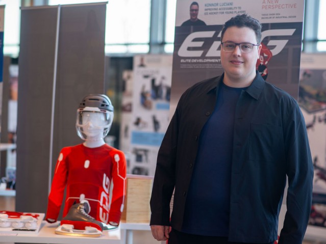 Student poses for photo with their hockey related project