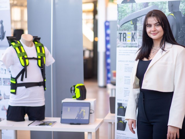 Student stands with their project display