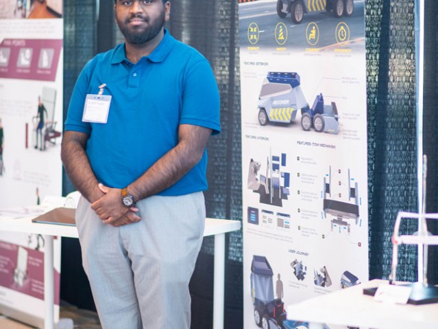 Student stands with their project display