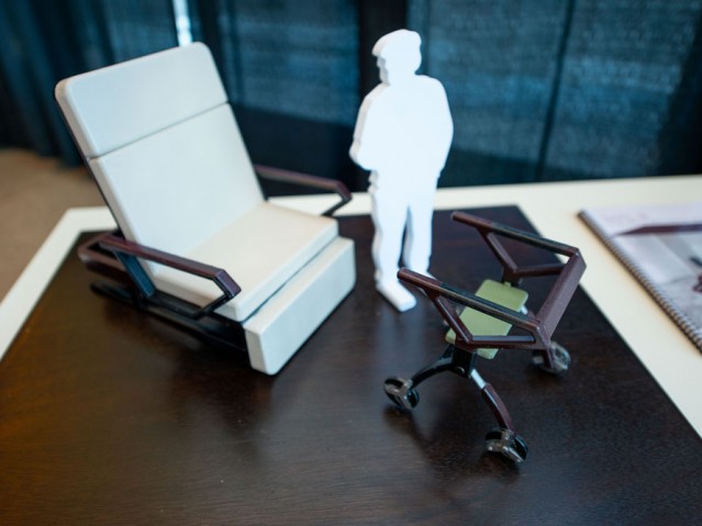 Physical 3D model of figure beside a chair and walker