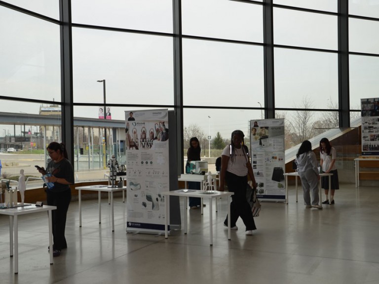 People inside building atrium looking at project displays