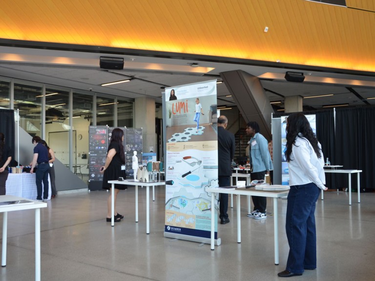 People standing beside their project tables