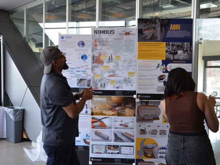 Two people in front of project posters