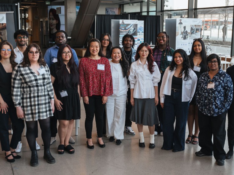 Design graduates and professor smiling for photo