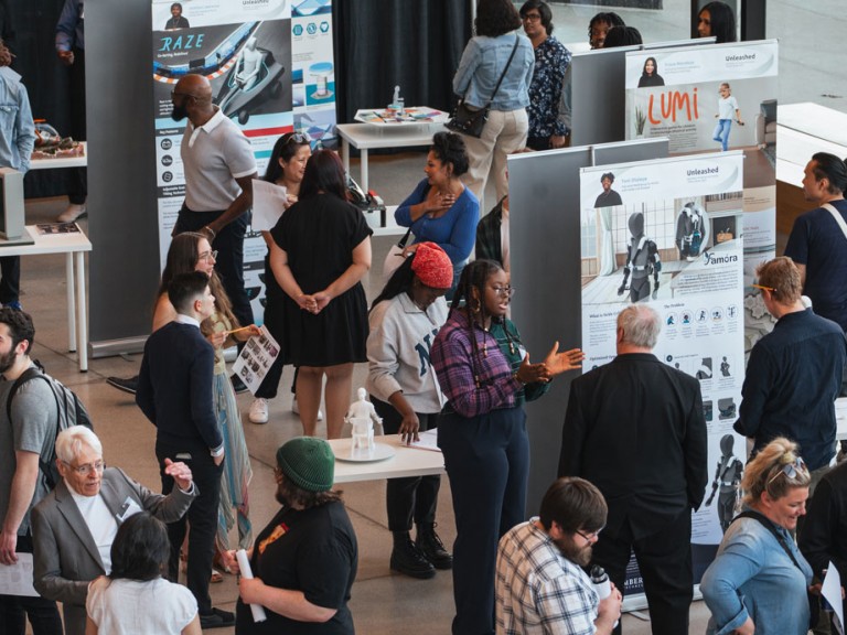 People mingling and talking around project displays