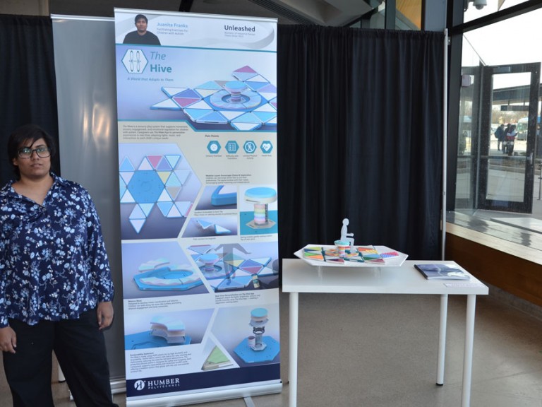 Industrial design graduate Juanita Franks standing beside their project display 