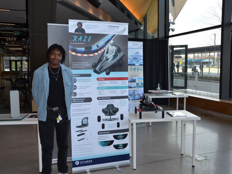 Industrial design graduate Jazmine Lawrence standing beside project display