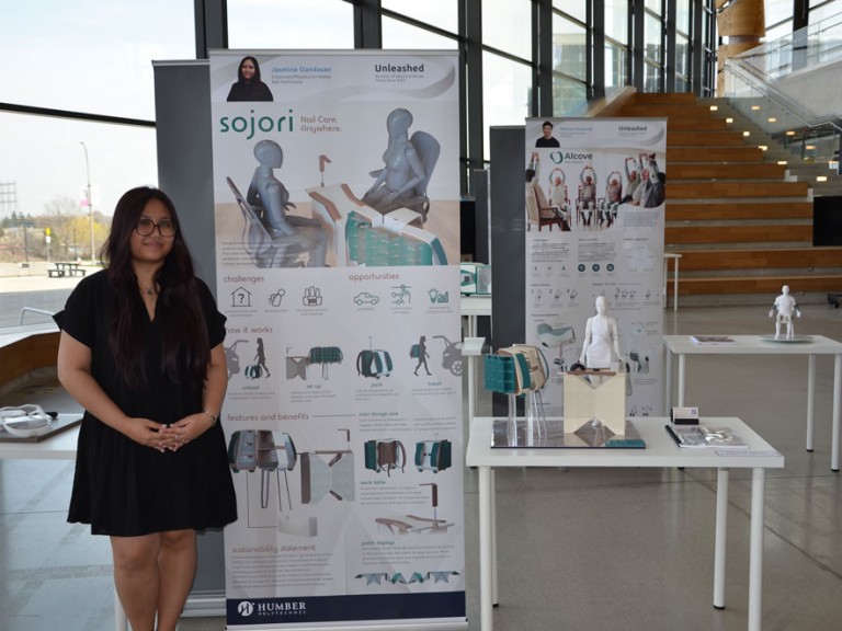 Industrial design graduate Jasmine Oandasan standing beside project display