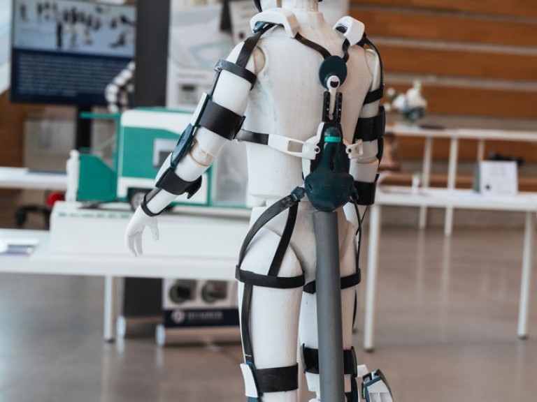 Physical 3D model of figure wearing assistive device design from the back