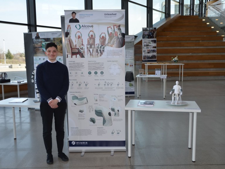Industrial design graduate Melissa Passarelli standing beside project display