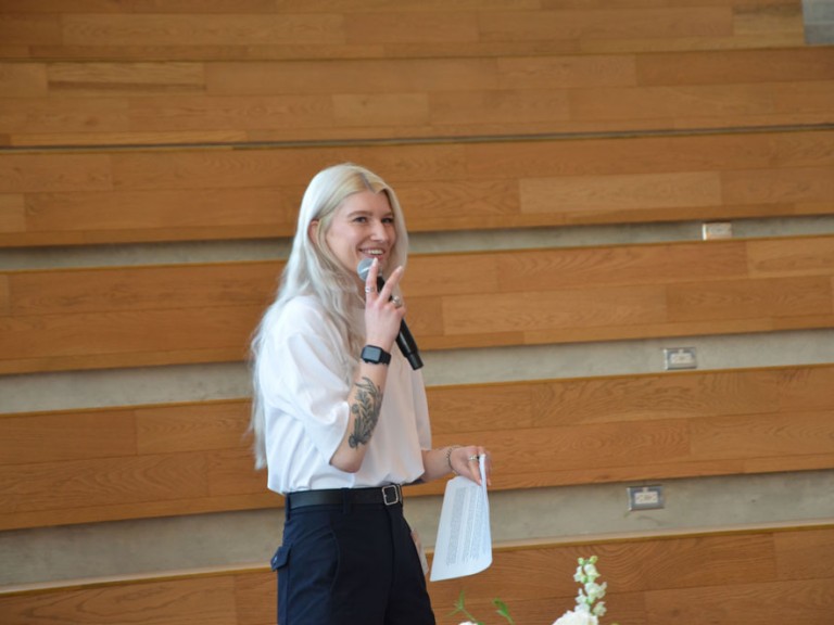 Person smiling with microphone in their hand