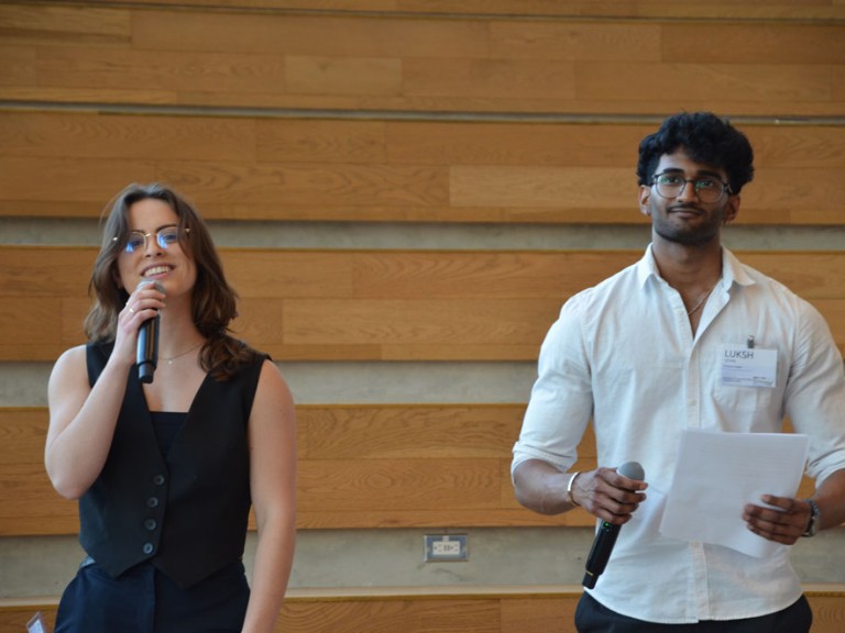Two people standing with microphones