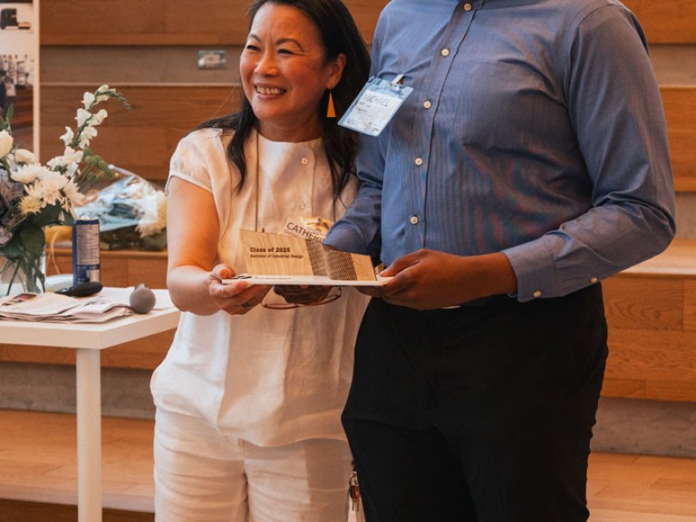 Design graduate and professor smiling for photo