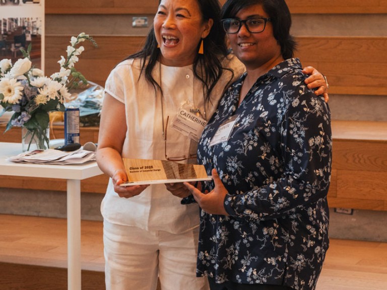 Design graduate and professor smiling for photo
