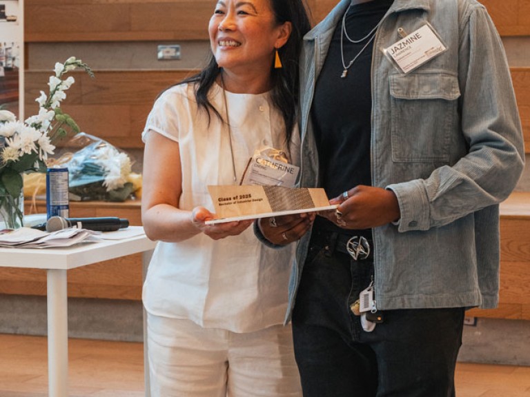 Design graduate and professor smiling for photo