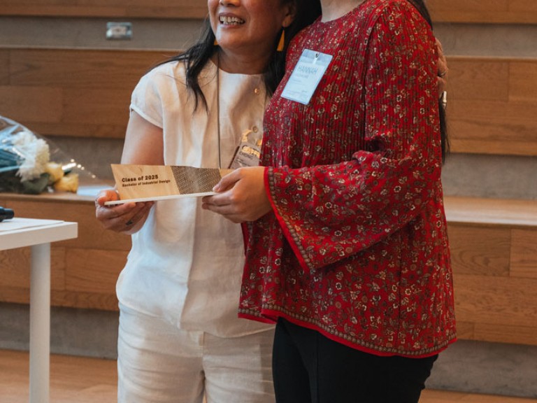 Design graduate and professor smiling for photo