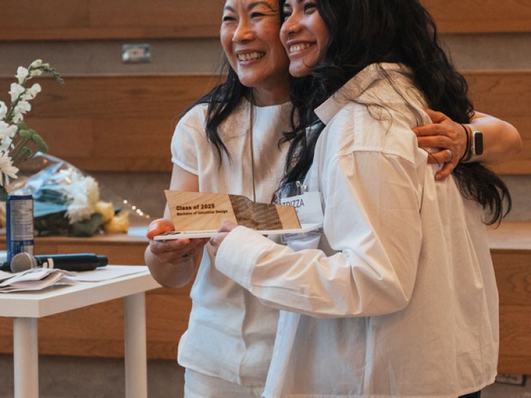 Award winning design graduate and professor smiling for photo
