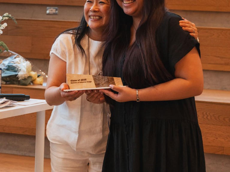Award winning design graduate and professor smiling for photo