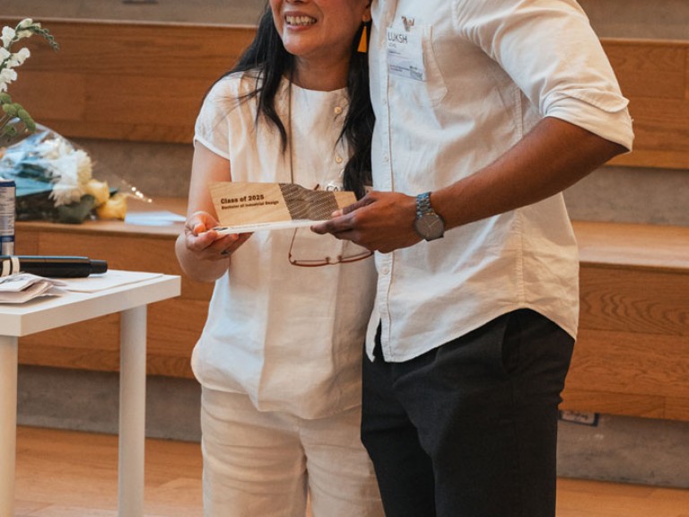 Design graduate and professor smiling for photo