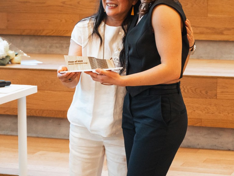 Design graduate and professor smiling for photo