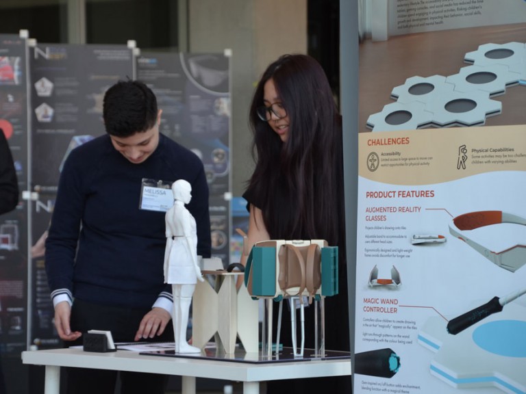 Two people behind project display table