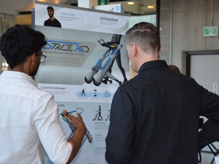 Two people in front of project poster