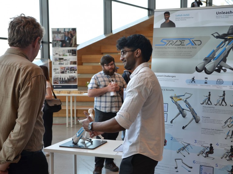 Graduate Luksh Uchil talking to guests in front of his project display