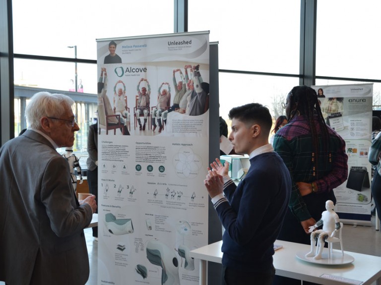 Graduate discussing project with guest
