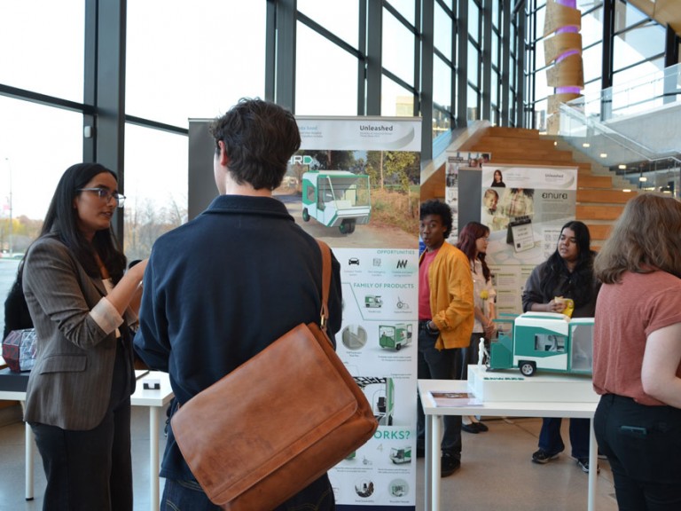 Two people talking in front of project poster